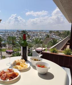 una mesa con una botella de vino y platos de comida en Tranquilo apartamento con vistas al mar. en Port d'Alcudia