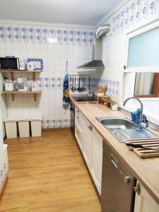 eine Küche mit einer Spüle und Holzböden in der Unterkunft Tranquilo apartamento con vistas al mar. in Port d'Alcúdia