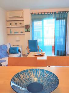 ein Wohnzimmer mit einer blauen Schale auf einem Tisch in der Unterkunft Tranquilo apartamento con vistas al mar. in Port d'Alcúdia