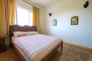 a bedroom with a bed with a large window at Apart a 450 metros da Praia de Ponta Negra RJ in Jaconé