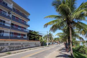 a palm tree on a street next to a building at Apart a 450 metros da Praia de Ponta Negra RJ in Jaconé