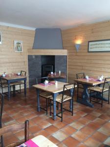 un restaurante con mesas y sillas y una chimenea en Hôtel des Cimes, en Luz-Saint-Sauveur