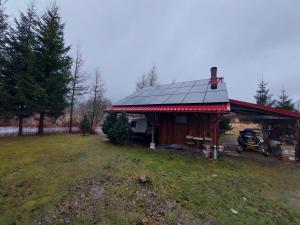 uma casa com uma moto estacionada em frente em Na Pograniczu domek w górach em Lasowka