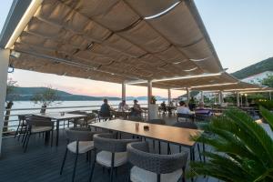 un restaurante con mesas y sillas y vistas al agua en Hotel Porat, en Neum
