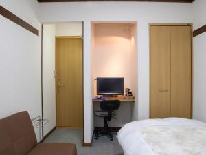 um quarto com uma cama e uma secretária com um computador em Ryokan Seifuso - Vacation STAY 02201v em Matsumoto
