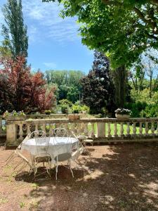 Una mesa y sillas frente a una valla en La Villa de Lise, en Romans-sur-Isère