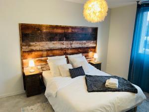 um quarto com uma cama grande e uma cabeceira em madeira em Superbe T3 proche de l'hypercentre de Lorient avec terrasse em Lorient