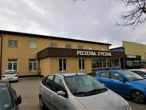 a parking lot with cars parked in front of a pizza oven at Gostišče Zvezda Ljutomer in Ljutomer