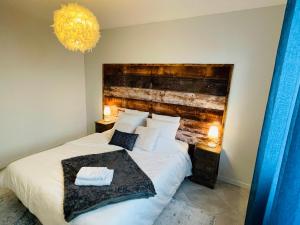 sypialnia z dużym łóżkiem z drewnianym zagłówkiem w obiekcie Superbe T3 proche de l'hypercentre de Lorient avec terrasse w mieście Lorient