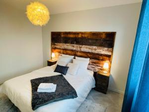 a bedroom with a large bed with a wooden headboard at Superbe T3 proche de l'hypercentre de Lorient avec terrasse in Lorient