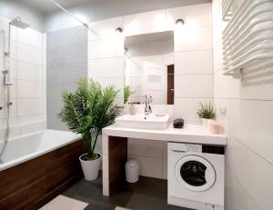 baño blanco con lavadora y lavamanos en Apartament Peowiaków Queens en Lublin