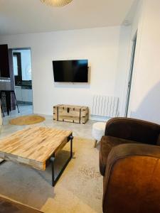a living room with a coffee table and a flat screen tv at Superbe T3 proche de l'hypercentre de Lorient avec terrasse in Lorient