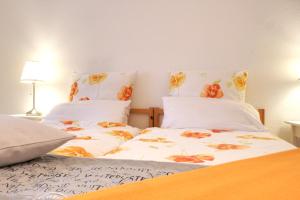 een slaapkamer met 2 bedden met witte lakens en oranje bloemen bij Ferienwohnung Heimaterde in Mülheim an der Ruhr