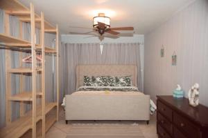 1 dormitorio con 1 cama y ventilador de techo en Charming home with hot tub, minutes from the beach en Vero Beach