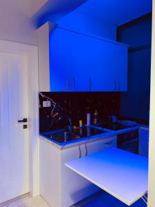 uma cozinha azul com um lavatório e um balcão em Lovely Apartment at the city of Tirana em Tirana