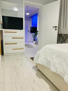 um quarto com uma cama e uma televisão de ecrã plano em Lovely Apartment at the city of Tirana em Tirana