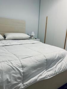 - un grand lit blanc avec une couverture blanche dans l'établissement Cozy Corner, à Tirana