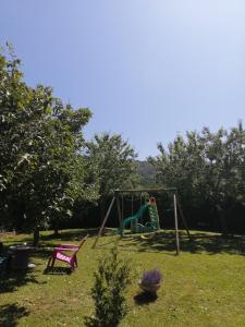 un parque infantil en un patio con un columpio en Chez Pat & Mat en La Canourgue