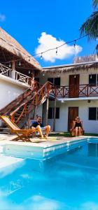 twee mannen zitten in een zwembad naast een huis bij Hotel Xa´an Bacalar in Bacalar
