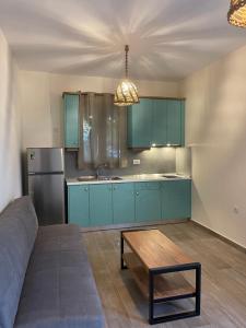 una cocina con armarios azules y una mesa. en Sea and city apartments en Cos