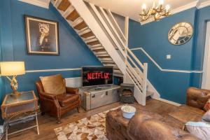 sala de estar con paredes azules y escalera en Sunnymead en Torquay