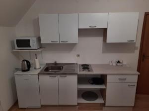 a small kitchen with white cabinets and a sink at Apartman Stars in Slavonski Brod