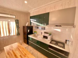 uma cozinha com um fogão e um micro-ondas em Polar House ShinKaruisawa1 - Vacation STAY 00271v em Karuizawa