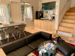 ein Wohnzimmer mit einem Sofa und einem Tisch in der Unterkunft Polar House ShinKaruisawa1 - Vacation STAY 00271v in Karuizawa
