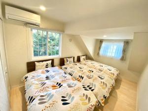 1 dormitorio con 2 camas y ventana en Polar House ShinKaruisawa1 - Vacation STAY 00271v, en Karuizawa