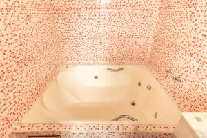 a bath tub in a bathroom with mosaic tiles at Pousada Luz do Sol in Paraty