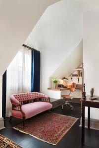a living room with a pink couch and a desk at The High Line Hotel in New York