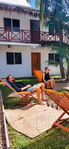 twee vrouwen in hangmatten voor een huis bij Hotel Xa´an Bacalar in Bacalar