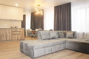 a living room with a couch and a kitchen at Prestige Apartments Berezinka in Dnipro
