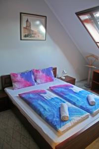 a bedroom with a large bed with blue and pink at Borbarát Vendégház in Eger