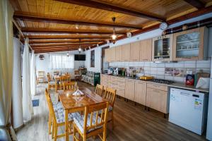 a kitchen and dining room with a table and chairs at Casa Luca in Vişeu de Jos