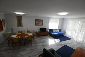 a living room with a table and a blue couch at Borbarát Vendégház in Eger
