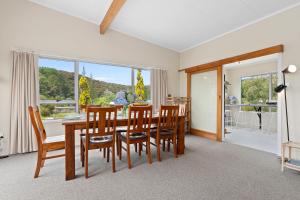 a dining room with a table and chairs and a large window at Tahuna Family Escape - Paihia Holiday Home in Paihia