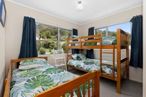 a bedroom with two bunk beds and a window at Tahuna Family Escape - Paihia Holiday Home in Paihia