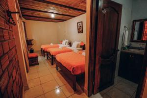 Un grupo de 4 camas en una habitación en Hosteria Orkidea Lodge, en Puyo