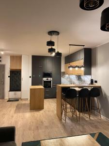 a kitchen with a table and some black cabinets at Apartament z widokiem na jezioro Niegocin, Mazury in Wilkasy