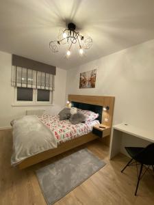 sypialnia z łóżkiem i żyrandolem w obiekcie Apartament z widokiem na jezioro Niegocin, Mazury w mieście Wilkasy