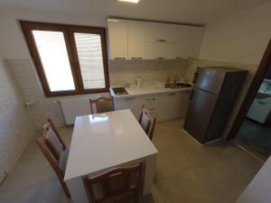 布雷佐維采的住宿－Mountain House - Brezovica，厨房配有白色的桌子和冰箱。
