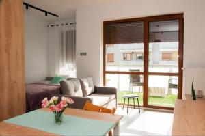 ein Wohnzimmer mit einem Sofa und einem Tisch in der Unterkunft Apartament na Piernikowym z miejscem postojowym in Toruń