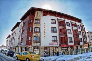 a yellow car parked in front of a building at Bansko SPA Studio at Predela1 in Bansko