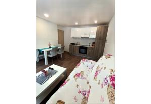 sala de estar con 2 camas y cocina en Apartments Mici, en Bled