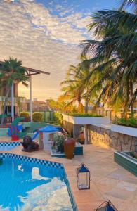 a swimming pool on the roof of a building with palm trees at Hotel Mansão Marcieri in Aquiraz