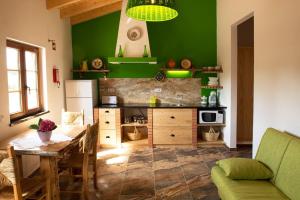 a kitchen with a table and a green wall at Quinta das Aguas in Aljezur