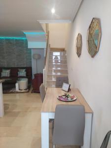 een woonkamer met een tafel, stoelen en een trap bij CASA ALFONSO in Córdoba