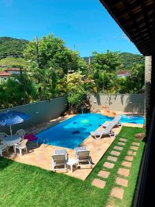 una piccola piscina con sedie e tavolo di Incrivel casa a 13 min a pe da Praia de Juquehy SP a São Sebastião
