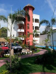 沙由利達的住宿－Hotel y Suites Los Encantos，前面有一辆汽车停在红色的建筑